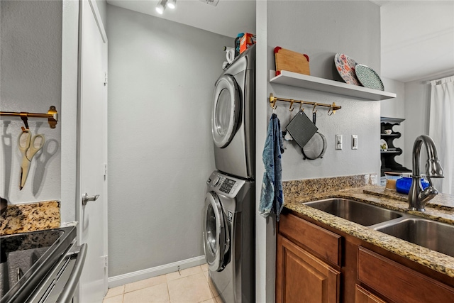 laundry room featuring stacked washer and dryer, sink, and light tile patterned floors