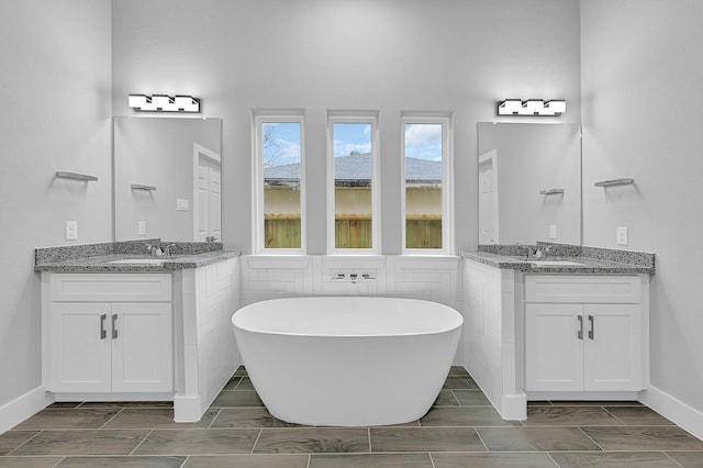 bathroom featuring vanity and a bath