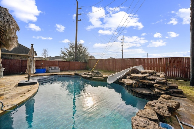 view of swimming pool featuring a patio and a water slide