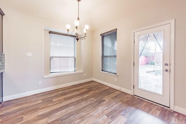 unfurnished dining area featuring hardwood / wood-style floors and a notable chandelier