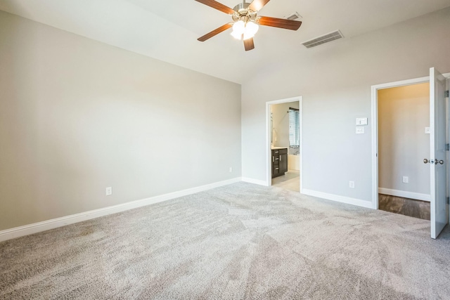 unfurnished bedroom with ceiling fan, lofted ceiling, connected bathroom, and light colored carpet