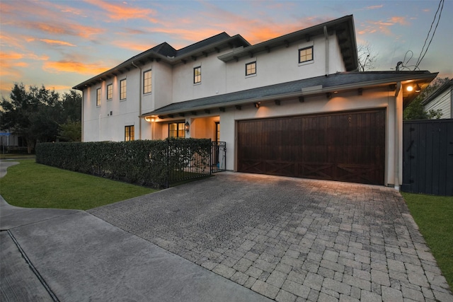 view of front of house featuring a garage and a lawn