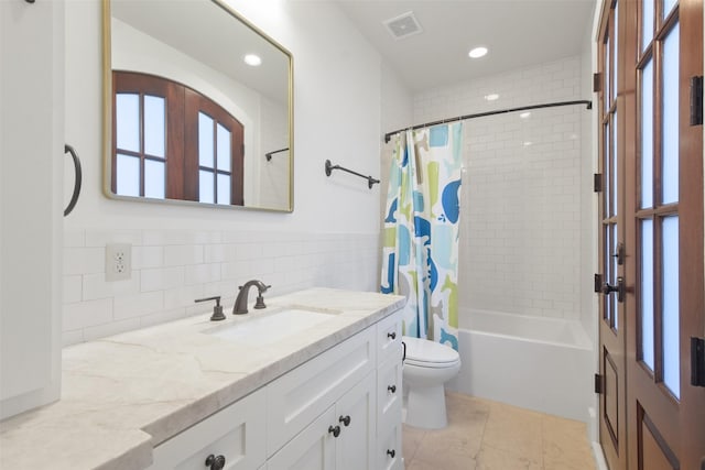 full bathroom featuring tile walls, shower / bath combination with curtain, vanity, toilet, and tile patterned floors