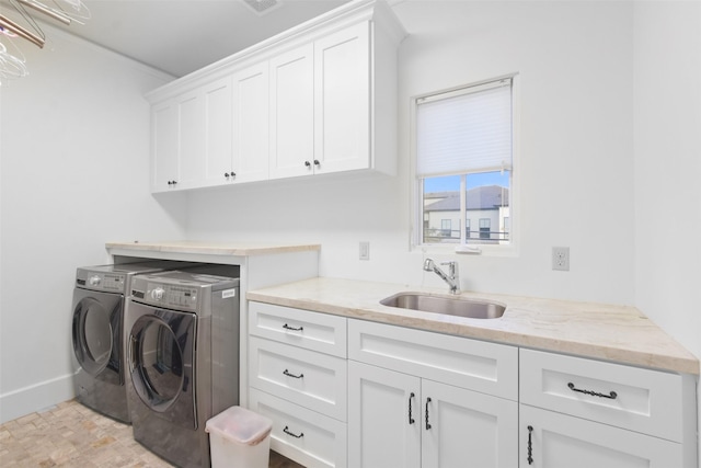 laundry room featuring sink, cabinets, and washing machine and clothes dryer