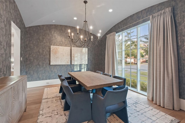 dining room with an inviting chandelier, vaulted ceiling, and light wood-type flooring