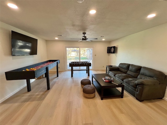 recreation room featuring ceiling fan, a textured ceiling, and light hardwood / wood-style flooring