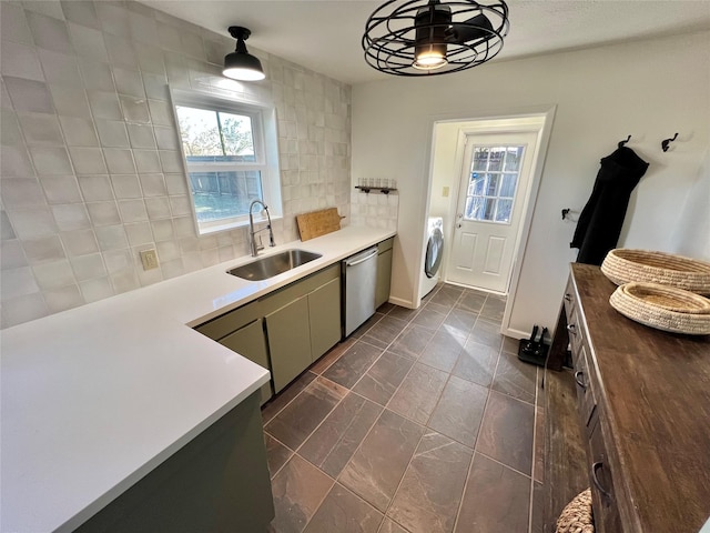 kitchen featuring washer / dryer, sink, stainless steel dishwasher, plenty of natural light, and decorative backsplash