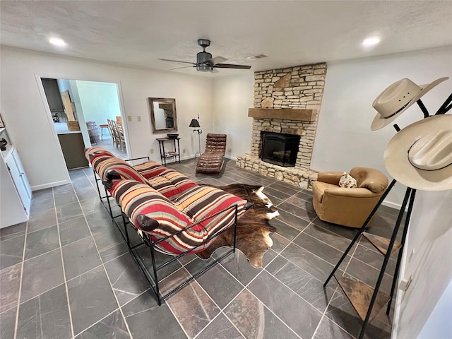 tiled living room with ceiling fan and a fireplace