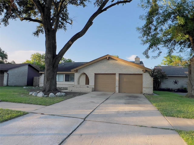 ranch-style home featuring a garage and a front lawn