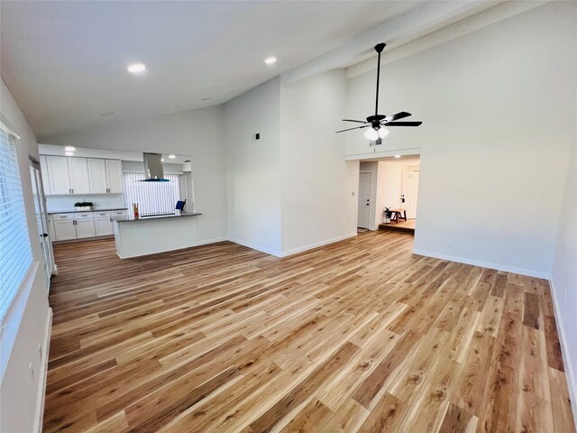 unfurnished living room with ceiling fan, high vaulted ceiling, and light wood-type flooring