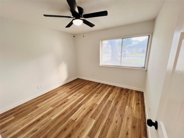 spare room with ceiling fan, a textured ceiling, and light wood-type flooring