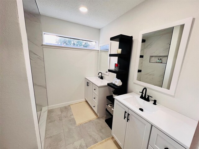 bathroom featuring walk in shower, vanity, and a textured ceiling