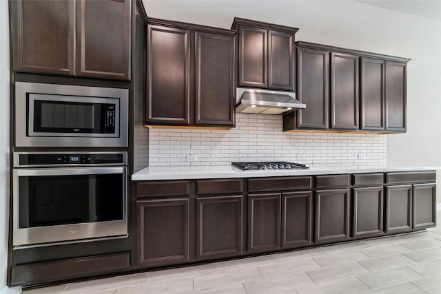 kitchen with stainless steel appliances, dark brown cabinetry, and decorative backsplash