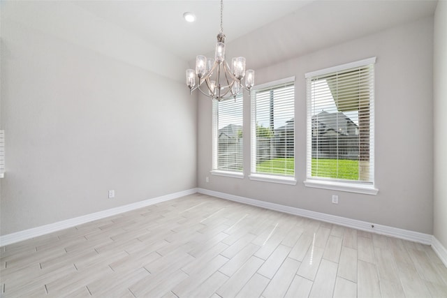 spare room featuring an inviting chandelier and plenty of natural light