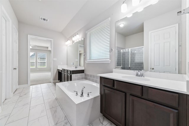 bathroom with vanity and shower with separate bathtub