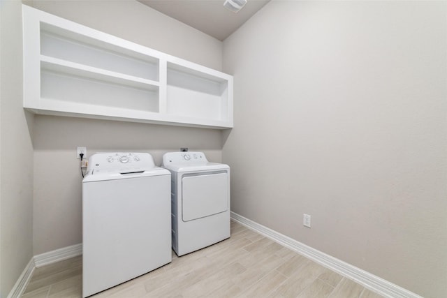 clothes washing area with light hardwood / wood-style flooring and independent washer and dryer