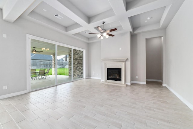 unfurnished living room featuring a premium fireplace, coffered ceiling, ceiling fan, and beam ceiling