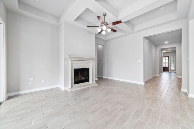 unfurnished living room featuring coffered ceiling, beam ceiling, a fireplace, and ceiling fan