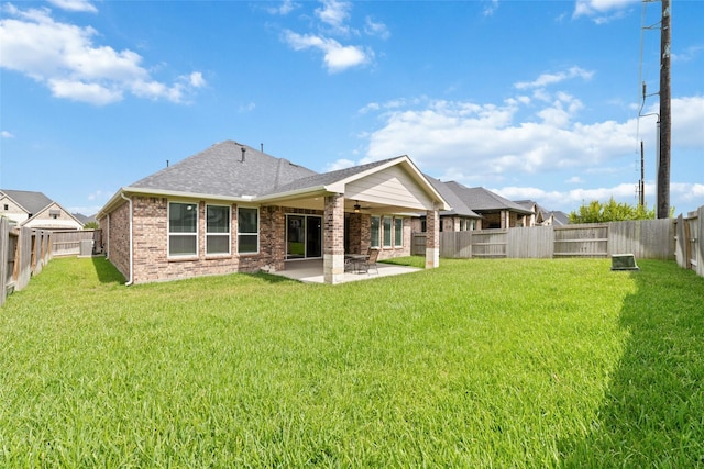 back of property featuring a yard, a patio area, and ceiling fan