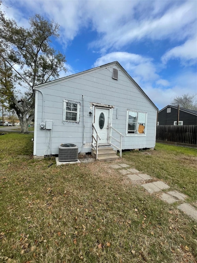 back of house with a yard and central AC