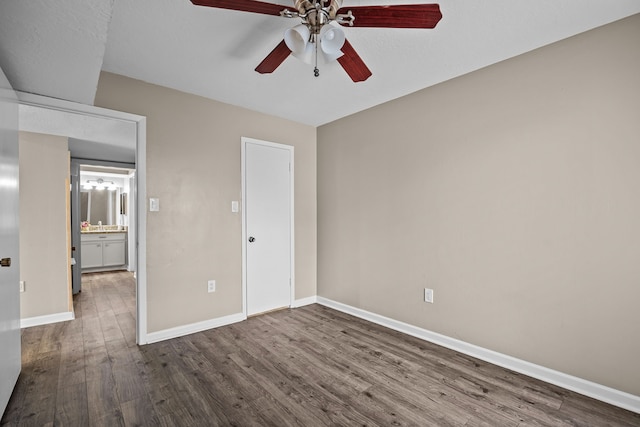 250 El Dorado Blvd Unit 127, Webster, TX 77598 - unfurnished bedroom featuring dark wood-type flooring, baseboards, and a ceiling fan