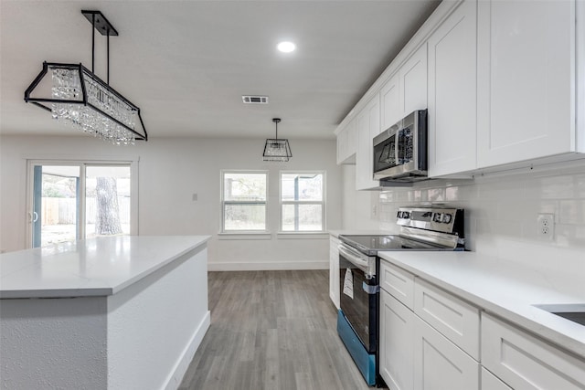 kitchen featuring white cabinetry, decorative backsplash, and appliances with stainless steel finishes