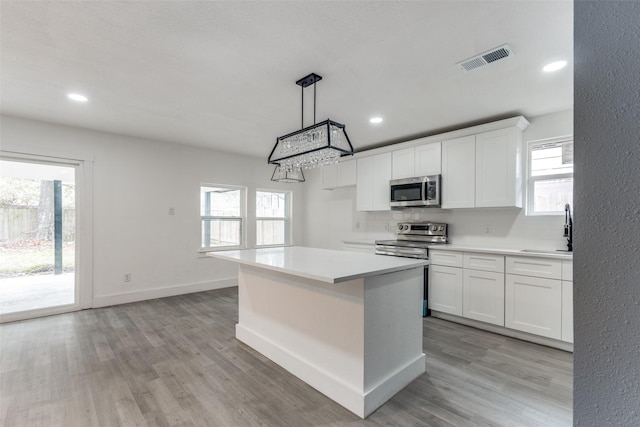 kitchen with appliances with stainless steel finishes, sink, white cabinets, and decorative backsplash