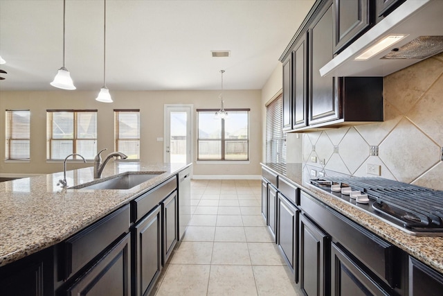 kitchen with pendant lighting, sink, extractor fan, light stone countertops, and light tile patterned flooring