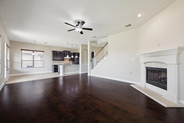 unfurnished living room featuring dark hardwood / wood-style floors and ceiling fan