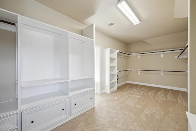 walk in closet with light colored carpet