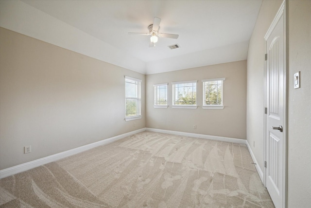 empty room with lofted ceiling, light colored carpet, and ceiling fan