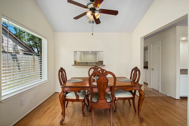 dining area with lofted ceiling, ceiling fan, and light wood-type flooring