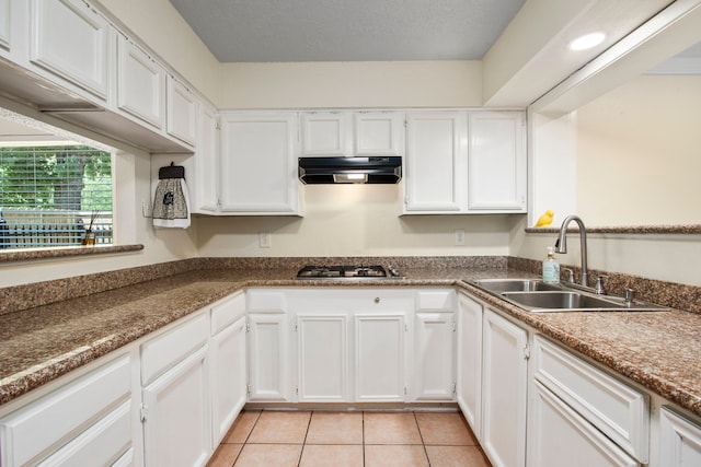 kitchen featuring white cabinetry, sink, and light tile patterned flooring