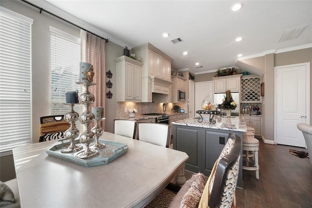 kitchen featuring dark wood-type flooring, a center island, a kitchen breakfast bar, stainless steel fridge, and light stone countertops