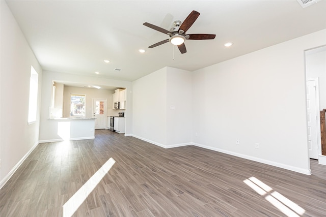 unfurnished living room featuring ceiling fan and hardwood / wood-style floors