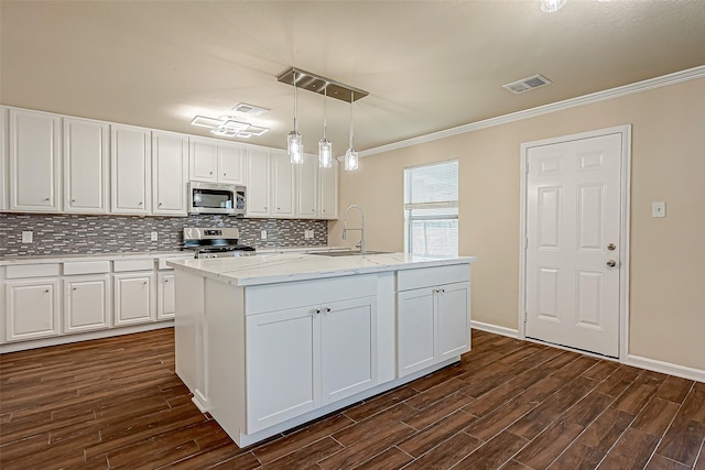 kitchen featuring white cabinetry, stainless steel appliances, decorative light fixtures, and sink