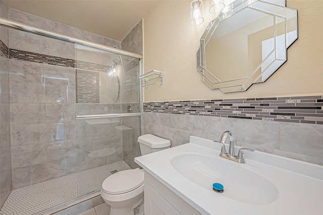 bathroom featuring vanity, tile walls, an enclosed shower, and toilet