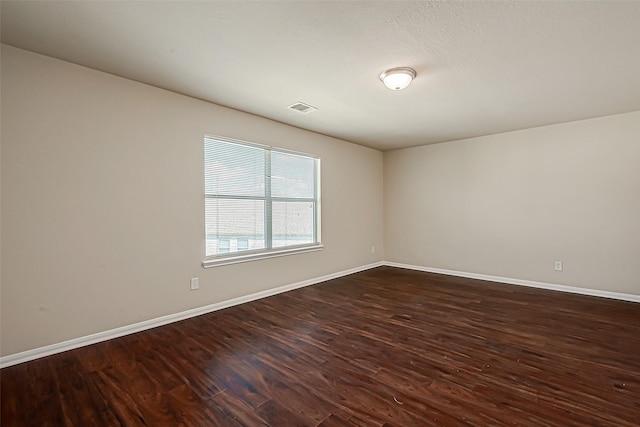 spare room with dark wood-type flooring