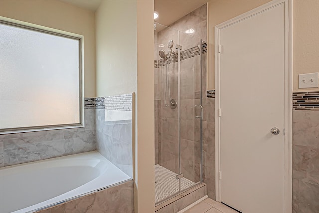 bathroom featuring tile patterned flooring and shower with separate bathtub