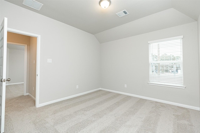 unfurnished room featuring light carpet and vaulted ceiling