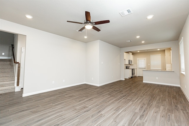 unfurnished living room featuring hardwood / wood-style flooring and ceiling fan