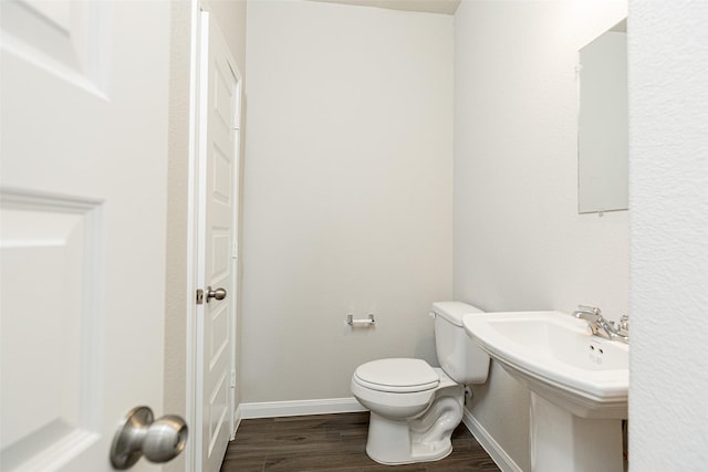 bathroom with hardwood / wood-style flooring and toilet