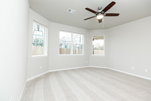 carpeted spare room featuring ceiling fan