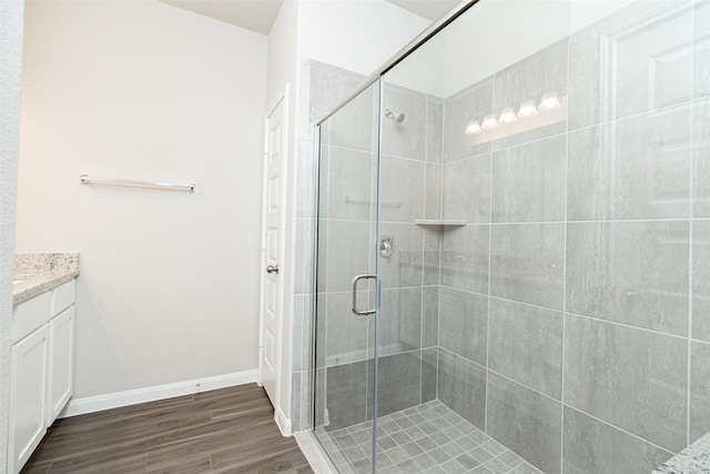 bathroom featuring wood-type flooring, vanity, and a shower with shower door