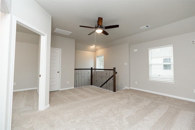 spare room with ceiling fan and light colored carpet