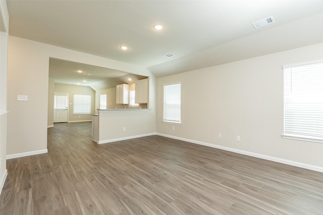 unfurnished living room with lofted ceiling and hardwood / wood-style floors