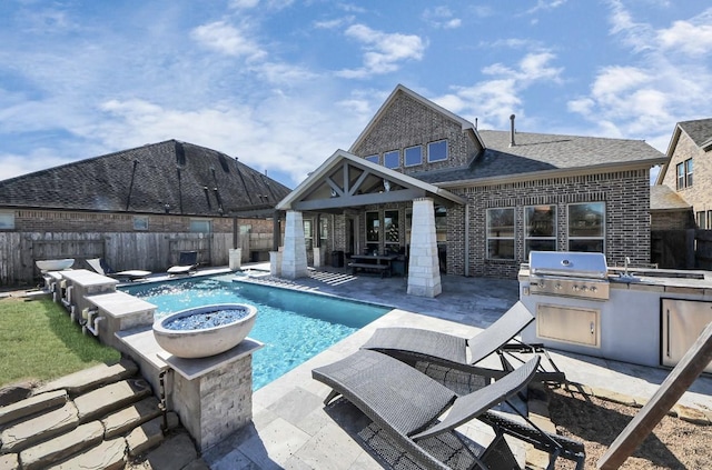 view of pool featuring an outdoor kitchen, area for grilling, and a patio area