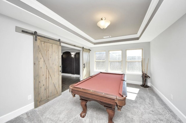 game room with ornamental molding, a barn door, a raised ceiling, and carpet