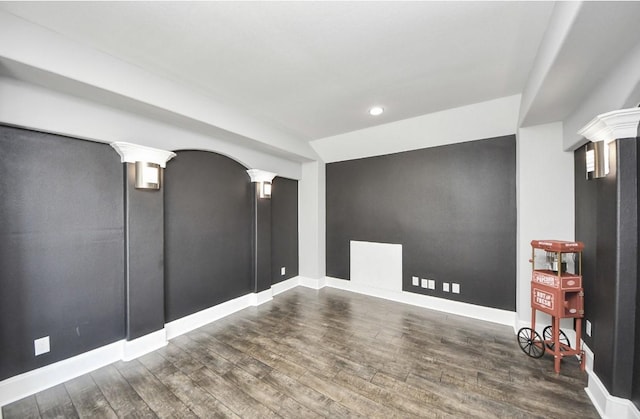 unfurnished room with dark wood-type flooring and ornate columns