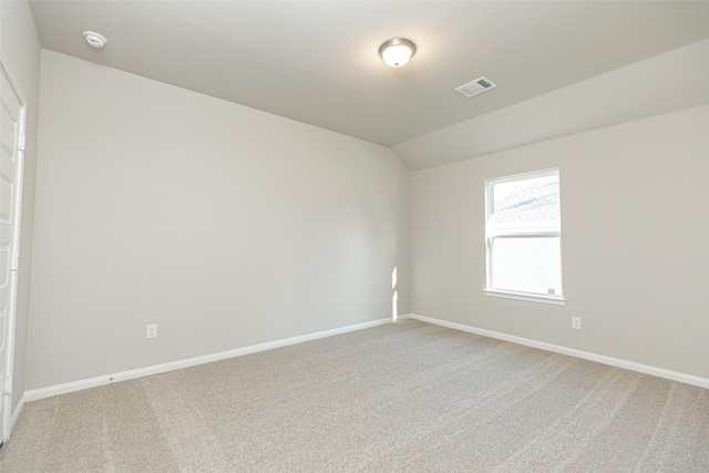 unfurnished room featuring vaulted ceiling and carpet flooring